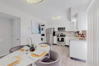 A modern kitchen with a dining table set for two.